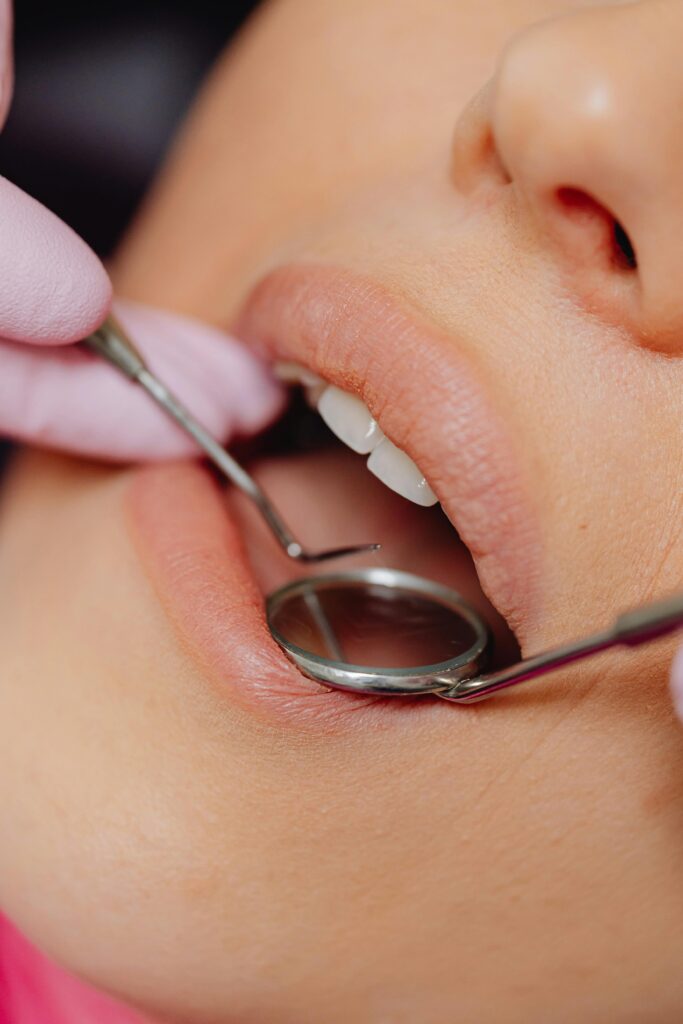 pexels photo 6627531 6627531 Close-up view of a patient's dental check-up using dental mirror and tools.